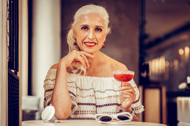 Smiling grey-haired woman with red lips wearing off-shoulder blouse - Фото, зображення