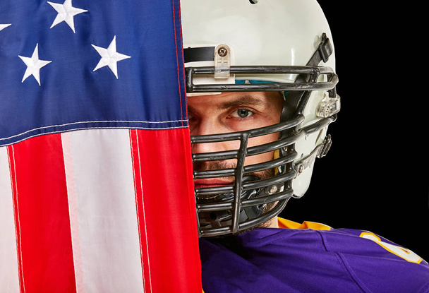 jugador de fútbol americano con uniforme y bandera americana orgulloso de su país, sobre un fondo blanco
. - Foto, imagen