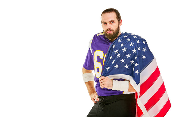 jugador de fútbol americano con uniforme y bandera americana orgulloso de su país, sobre un fondo blanco
. - Foto, imagen