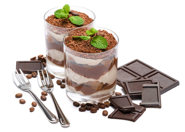 two portions Classic tiramisu dessert in a glass and chocolate bar isolated on a white background - Fotó, kép