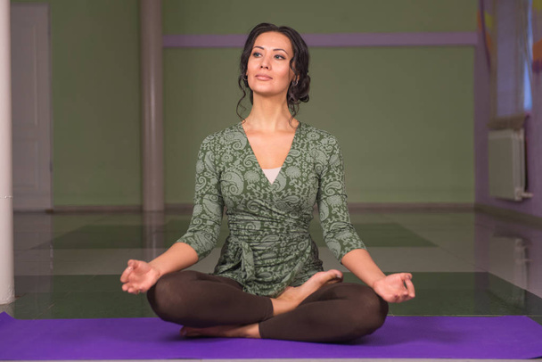 Yoga trainee shows yoga exercises in a studio - Photo, Image