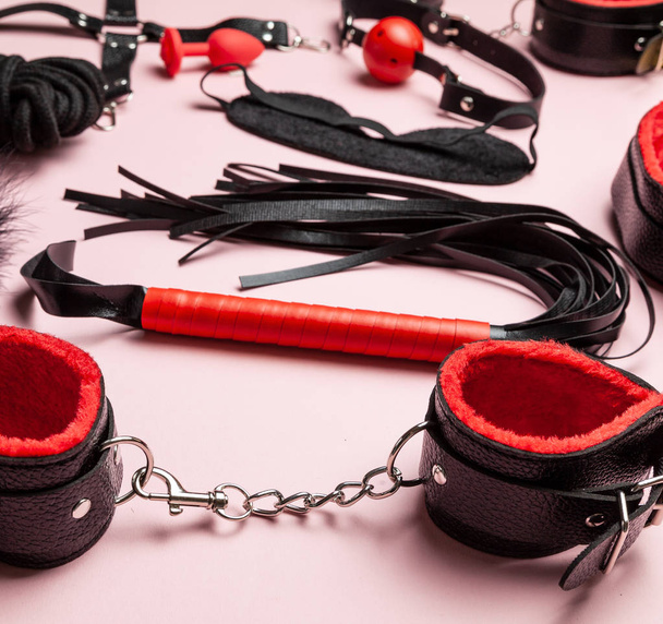 Set of erotic toys for BDSM. The game of sexual slavery with handcuffs, whip, gag and leather straps. Intimate sex games. - Fotoğraf, Görsel