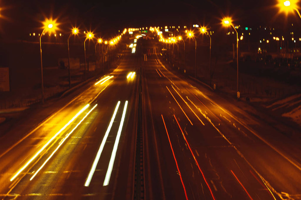 Міська алея вночі від висоти, видно світяться сліди автомобілів - Фото, зображення