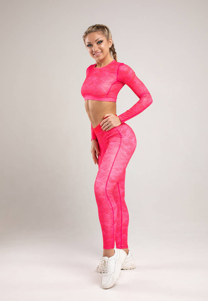 Fitness woman in pink sports bra and leggings, studio shot - Fotoğraf, Görsel