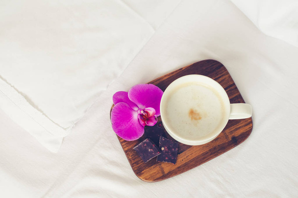 Cup of cappuccino on the bed - Photo, Image