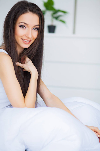 Relaxing On Bed During Weekend. Beautiful Woman Relaxing on a Bed and Looking Happy - Фото, изображение