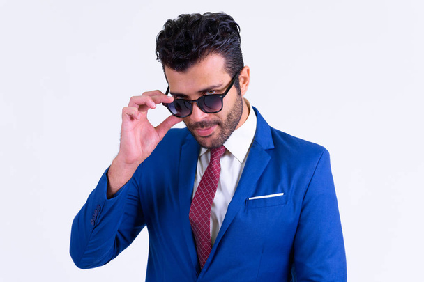 Portret van knappe bebaarde Perzische zakenman gluren over zonnebril - Foto, afbeelding