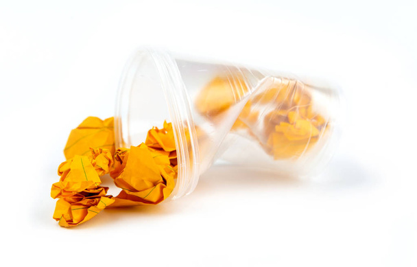 Concept of garbage and pollution. Crumpled plastic cup with oran - Photo, Image