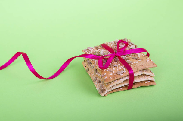 Biscuits faits maison sur un fond vert. biscuits diététiques avec bande. Pain croustillant aux graines de tournesol, lin et sésame
 - Photo, image