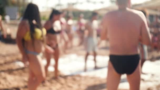 4k imágenes borrosas de la multitud bailando en la discoteca de la playa. Media y mujeres en bikini y trajes de baño divirtiéndose
. - Metraje, vídeo