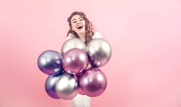 Young girl with balls on a colored background - Foto, imagen
