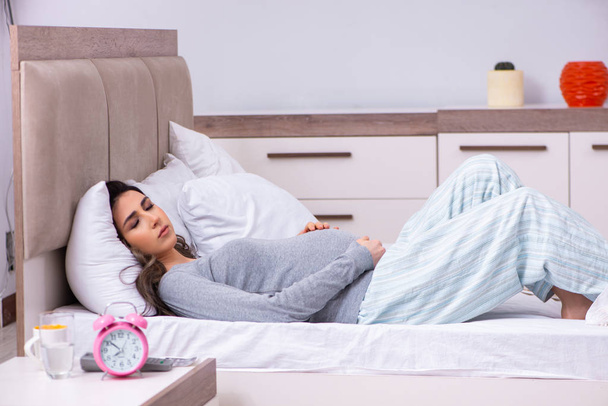 Junge schwangere Frau im Schlafzimmer  - Foto, Bild