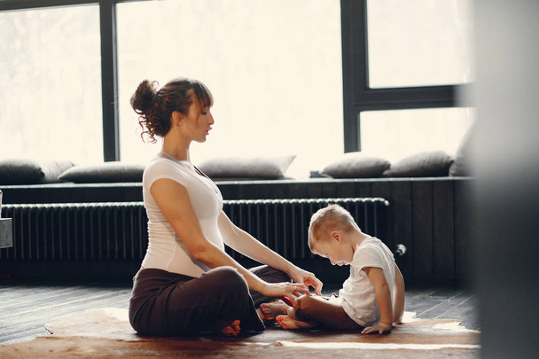Mother with little son doing yoga at home - Фото, зображення