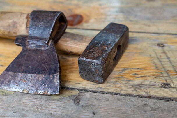 working tool ax sharp black big heavy hammer on a wooden planks background close-up - Zdjęcie, obraz