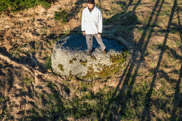 Młody człowiek turysta w czarnej czapce stanąć na kamieniu z góry, Novohradske - Zdjęcie, obraz