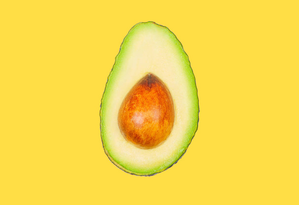 Avocado levitate in air on yellow pastel background. Concept of vegetable levitation. - Fotografie, Obrázek