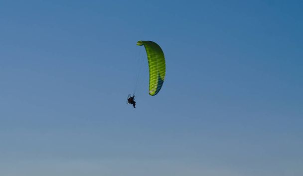 Parapente vert avec ciel bleu en arrière-plan
 - Photo, image