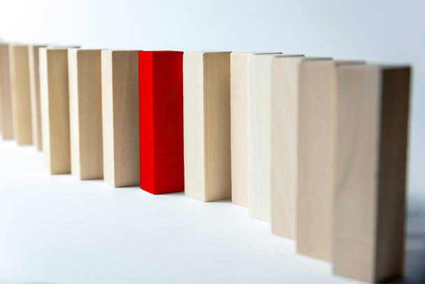 Una larga línea curva de cubos de madera con un rojo, como símbolo de una cola, competición por una posición o equipo, sobre un fondo blanco desigual. Marco horizontal
 - Foto, imagen