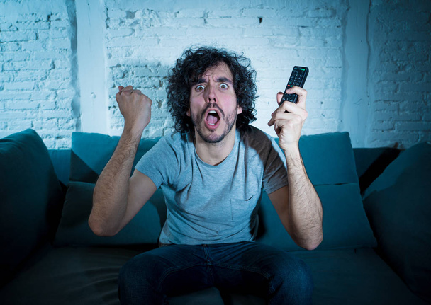 Lifestyle portrait of tv show fan man watching excited favorite series movie or soccer football game in online TV late at night. In people streaming content addiction and entertainment concept. - Photo, Image