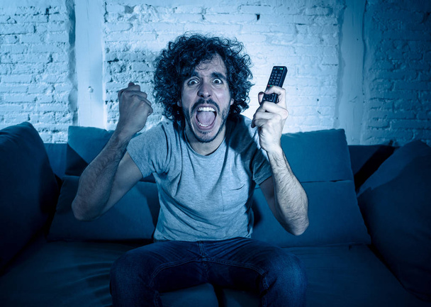 Lifestyle portrait of tv show fan man watching excited favorite series movie or soccer football game in online TV late at night. In people streaming content addiction and entertainment concept. - Foto, Bild