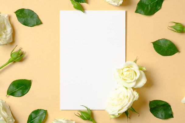 Spring flowers. White flowers and green leaves on pastel yellow background. Flat lay, top view, copy space. Creative layout, flower arrangement concept. - Valokuva, kuva
