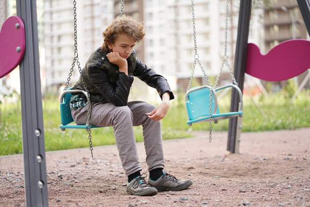 Triste adolescente solitario all'aperto sul parco giochi. le difficoltà dell'adolescenza nel concetto di comunicazione
.  - Foto, immagini