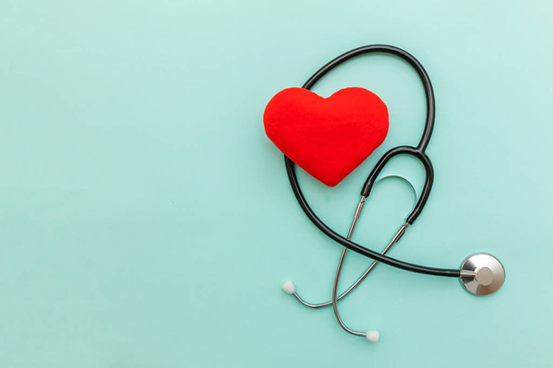 Lékařské vybavení stetoskop nebo fonendoskop a červené srdce izolované z módního pastelově modrého pozadí. Přístroj pro lékaře. Koncepce životního pojištění zdravotní péče - Fotografie, Obrázek
