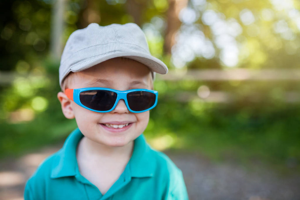 Mignon petit garçon portant de grandes lunettes de soleil en plastique foncé
 - Photo, image