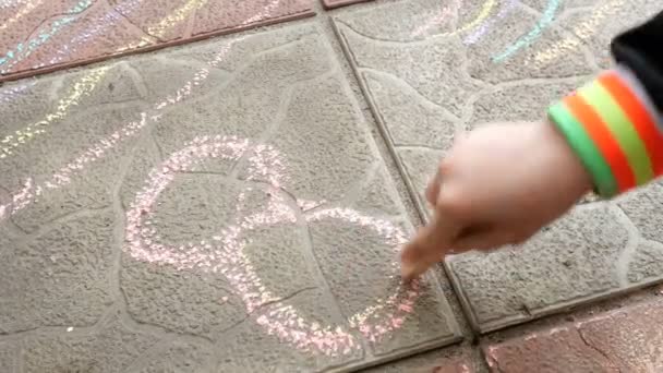 Το παιδί ζωγραφίζει ένα κομμάτι κιμωλία στο πάτωμα του πλακικού αριθμού οκτώ. - Πλάνα, βίντεο