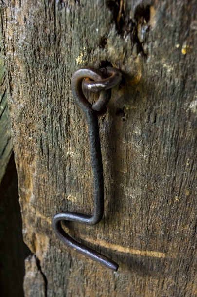Acero Rusty gancho de metal en la vieja puerta de madera. Gancho de hierro para cerrar la puerta o ventana
.  - Foto, imagen