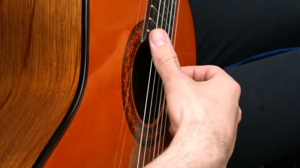 Músico de performance. O guitarrista toca com os dedos numa guitarra acústica de madeira. Ao ar livre. Close-up
. - Filmagem, Vídeo