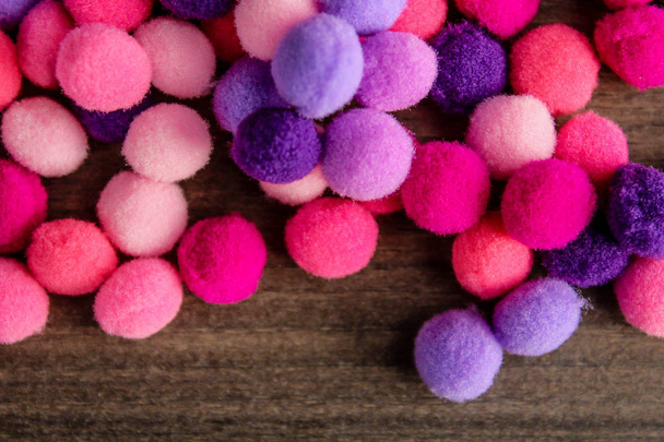 Bolas esponjosas redondas de color rosa y púrpura pompones sobre fondo de madera
 - Foto, Imagen
