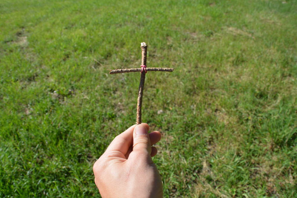 tenant dans la main une croix en bois faite par soi-même
 - Photo, image