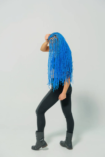 Russian girl with blue pigtails on a white background. Blue zizi on the head of a woman. Trained girl with dreadlocks on a light background - Photo, Image