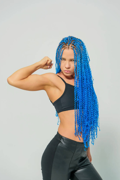 Russian girl with blue pigtails on a white background. Blue zizi on the head of a woman. Trained girl with dreadlocks on a light background - Foto, imagen