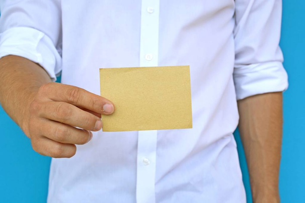 Мужчина в рубашке показывает чистую карточку бумаги
 - Фото, изображение