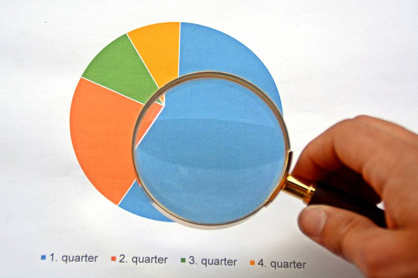 Человек, указывающий увеличительным стеклом на статистику
  - Фото, изображение