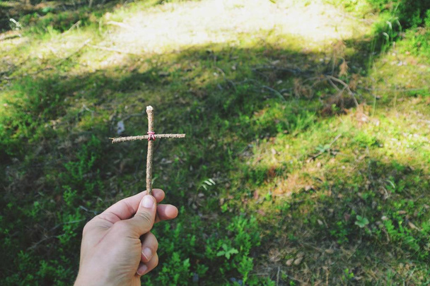 tenant dans la main une croix en bois faite par soi-même
 - Photo, image