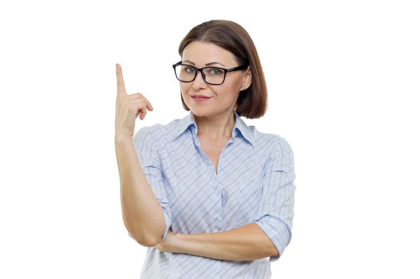 Portrait of middle-aged woman in glasses with index finger up, attention, white background isolated - Foto, imagen