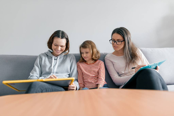Two sister girls talking with young woman family psychologist, children sitting in office - Photo, image
