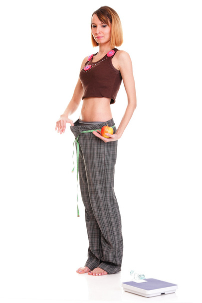 jonge vrouw apple uitvoering een gewicht-schaal - Foto, afbeelding