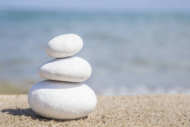 Stos kamieni żwirowych na równowagę na piaszczystej plaży - Zdjęcie, obraz