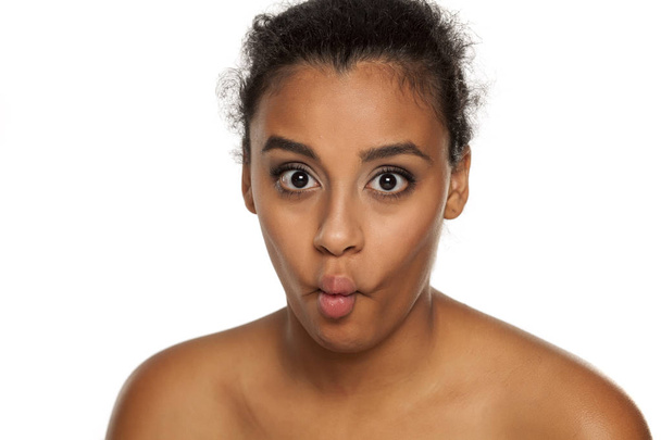 portrait of young dark-skinned woman making fish face on white background - Photo, Image