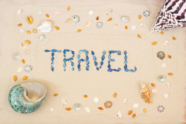 Sand on the beach in summer, the inscription travel from the shells on the sand. Flat lay. Top view - Foto, Imagen