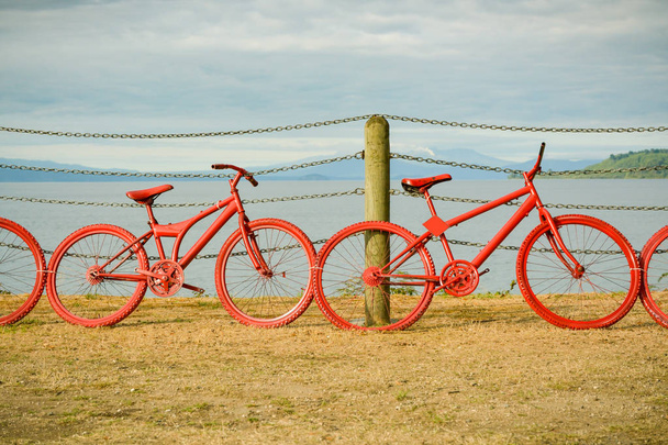 Czerwone malowane rowery na ogrodzeniu w pobliżu jeziora Taupo - Zdjęcie, obraz