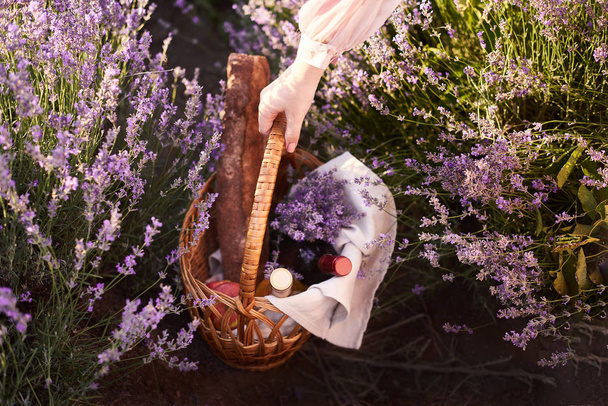 mujer sostiene cesta de mimbre y busca un buen lugar para el picnic
 - Foto, imagen