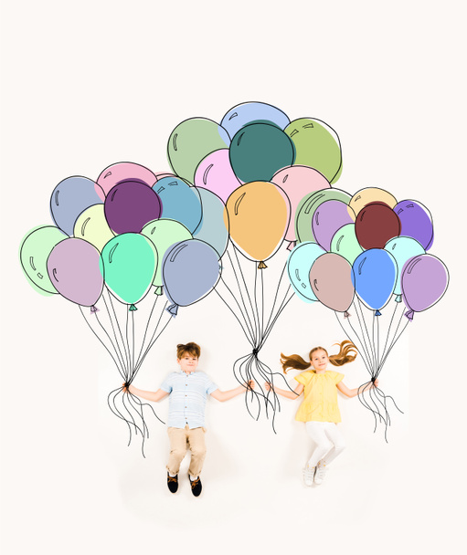 enfants gais tenant des ballons colorés et volant sur blanc
  - Photo, image