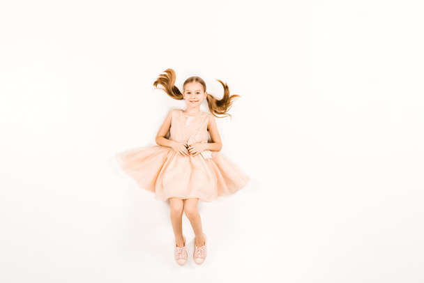 ylhäältä näkymä onnellinen lapsi vaaleanpunainen mekko katselee kameraa valkoinen
  - Valokuva, kuva