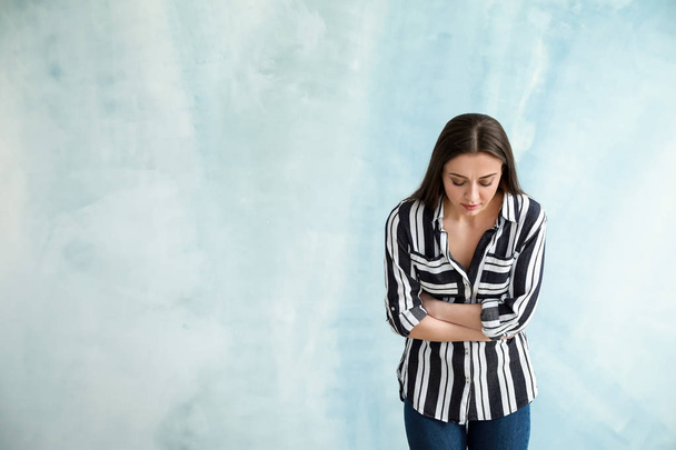 Vrouw die lijdt aan buikpijn op kleur achtergrond - Foto, afbeelding
