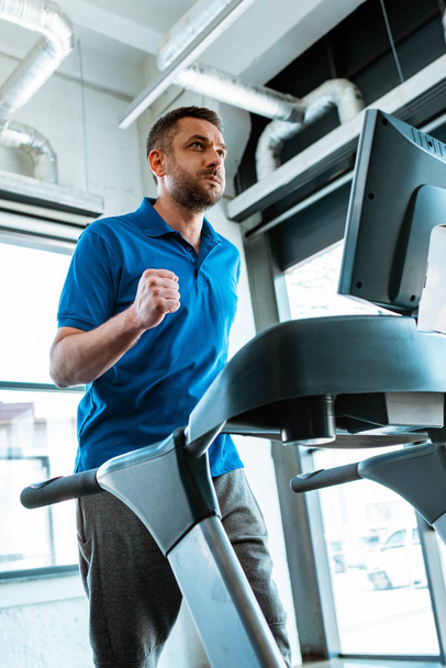 handsome man working out on treadmill at gym - Zdjęcie, obraz